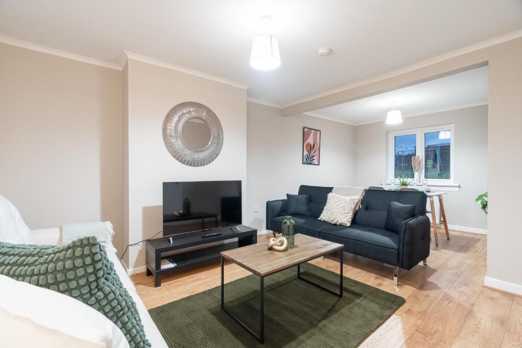 uma sala de estar com um sofá e uma mesa em Kingswood em Bishopton