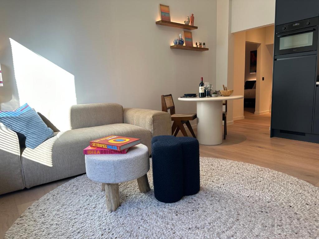 a living room with a couch and a table at Home away from home by the beach in Ostend
