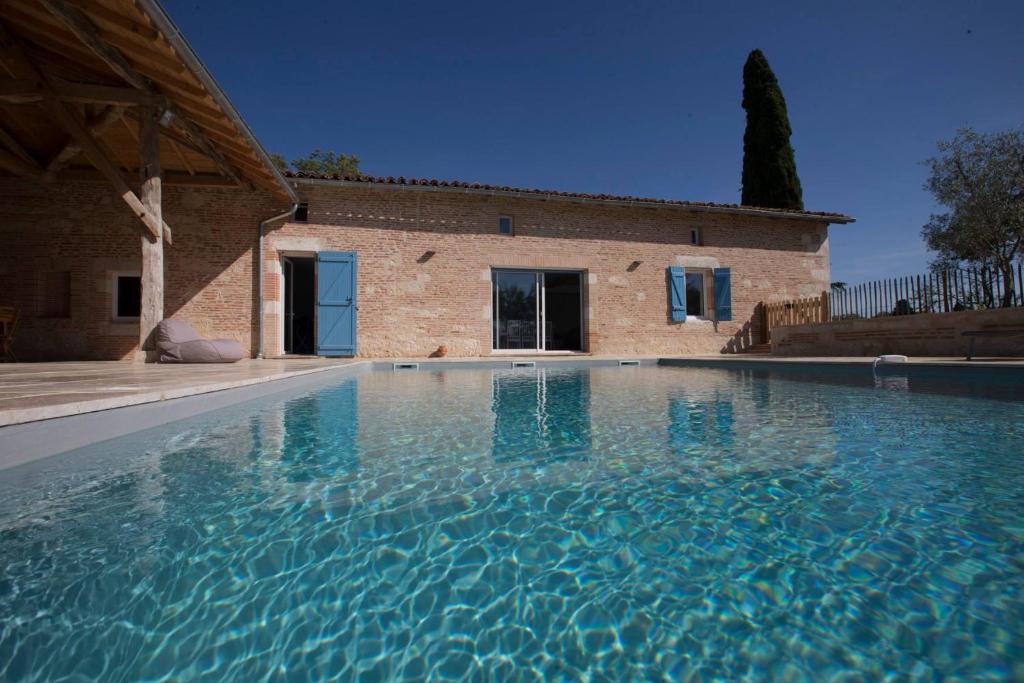 a large swimming pool in front of a house at Villa Virginie gite 1 