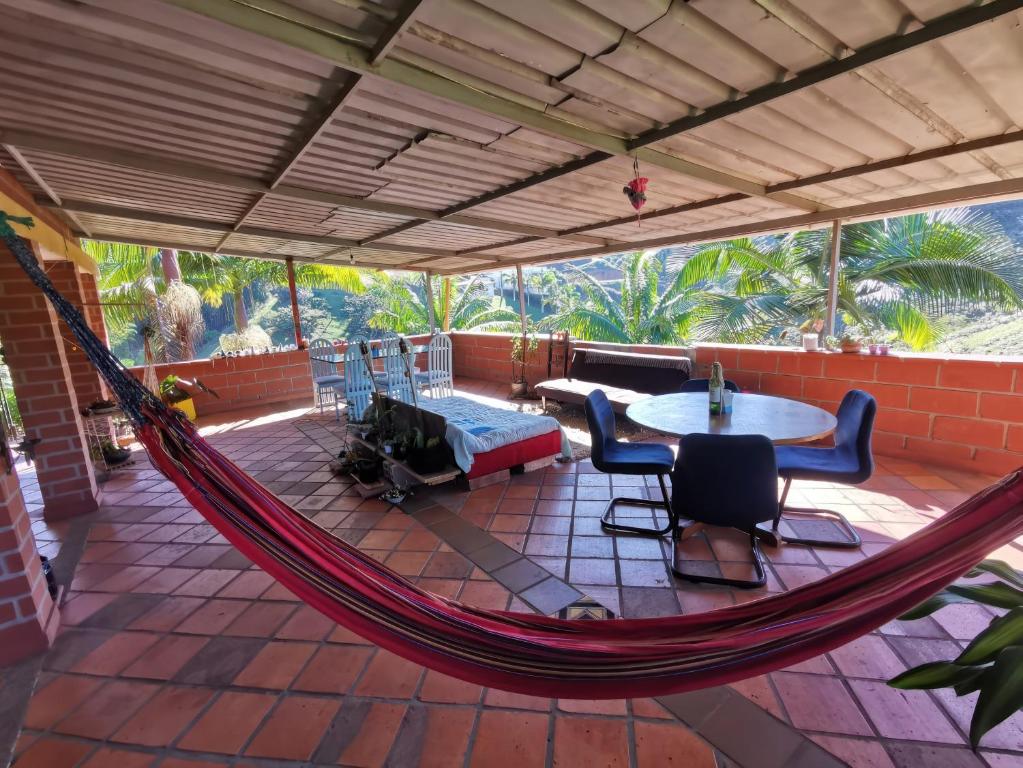 a hammock on a porch with a table and chairs at Casa para 12 personas Acceso a la represa y Barbacoa in Guatapé