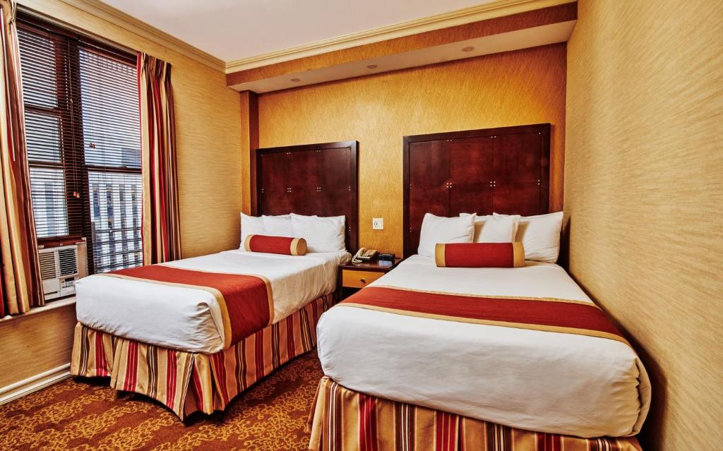 a hotel room with two beds and a window at Radio City Apartments in New York