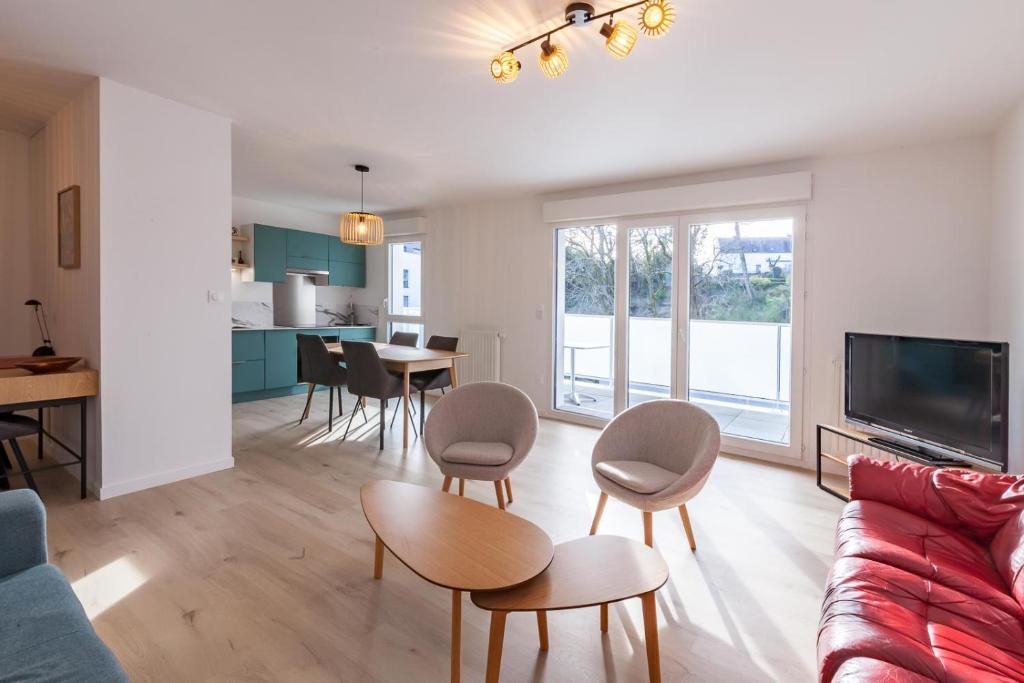 a living room with a couch and a table and chairs at Rohan - T3 - parking - calme - wifi in Vannes