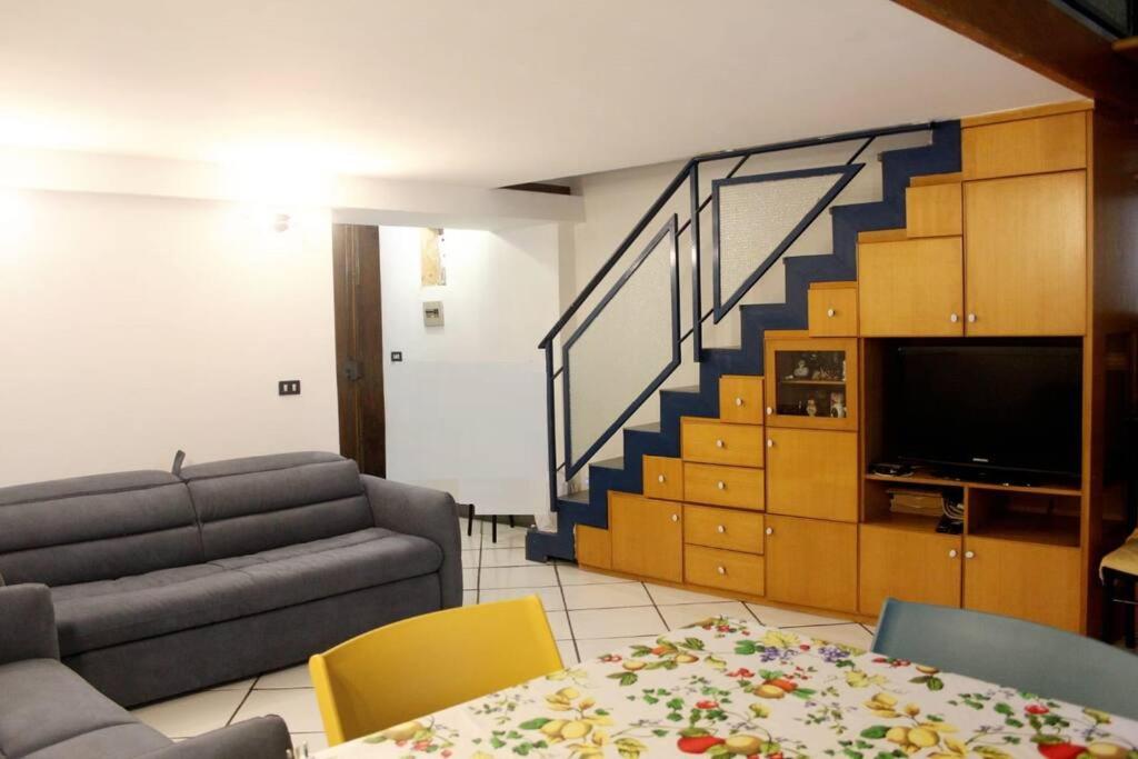 ein Wohnzimmer mit einem Sofa und einer Treppe in der Unterkunft Casa Rosa Atrani in Atrani