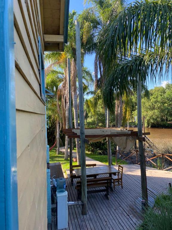 a wooden deck with a bench and a hammock at Hidden Island Hostel in Tigre