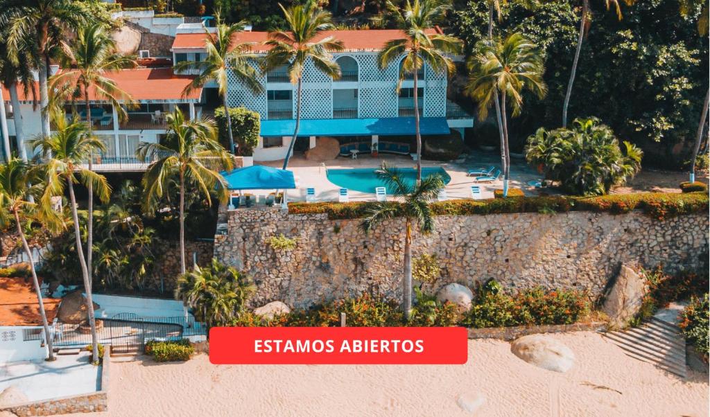an aerial view of a resort with palm trees at Maravillosa casa con 7 habitaciones, acceso directo a playa pichilingue, bahía de puerto marqués, zona diamante Acapulco in Acapulco