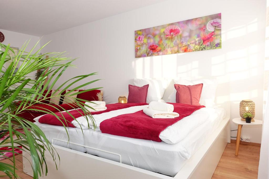 a bedroom with a red and white bed with plants at RELAX-RED mit Pool und Sauna in Scheidegg