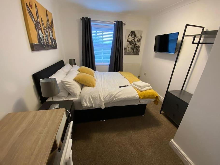 ein Schlafzimmer mit einem Bett mit gelber Bettwäsche und einem Fenster in der Unterkunft Huge 6 Bed house & 6 Bathrooms. in Boston