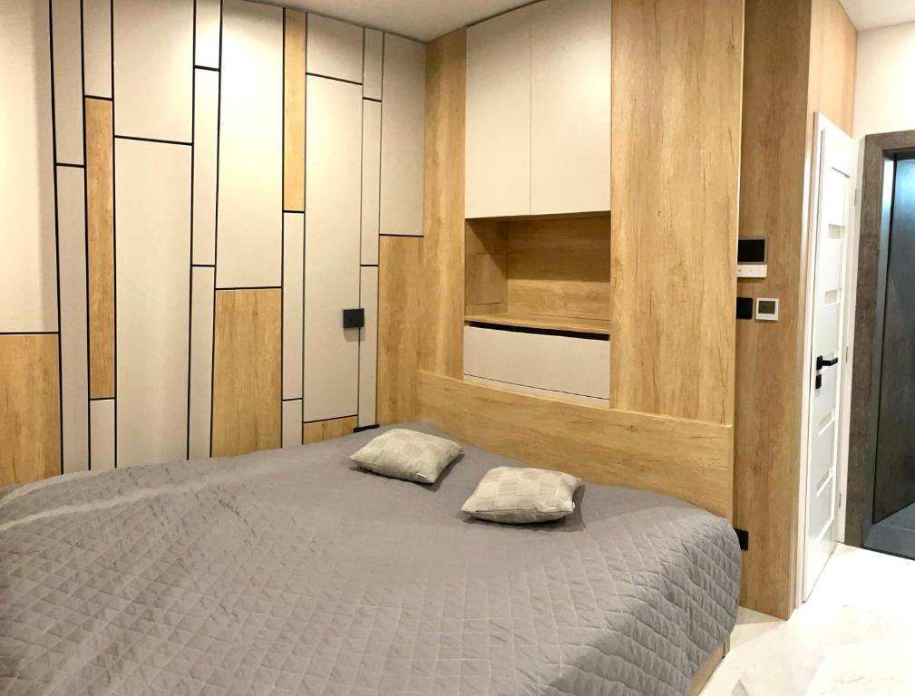 um quarto com uma cama grande e armários brancos em Green Side Studio em Michalovce