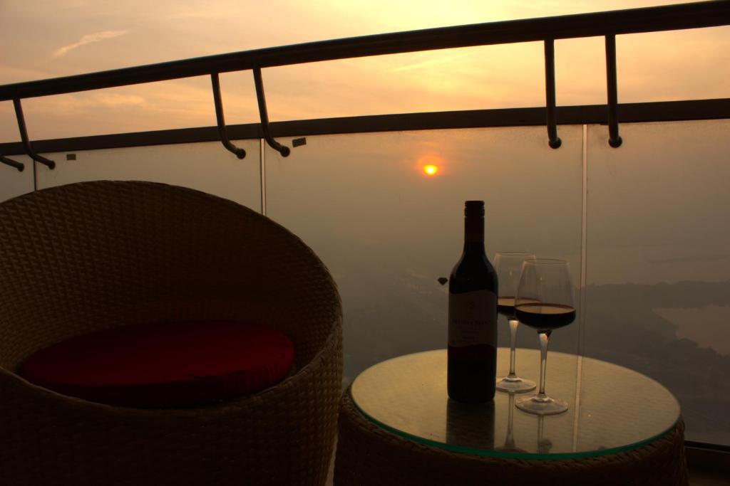 una bottiglia di vino seduta su un tavolo con un bicchiere di AmigosStay - High Rise Studio with river view. a Noida