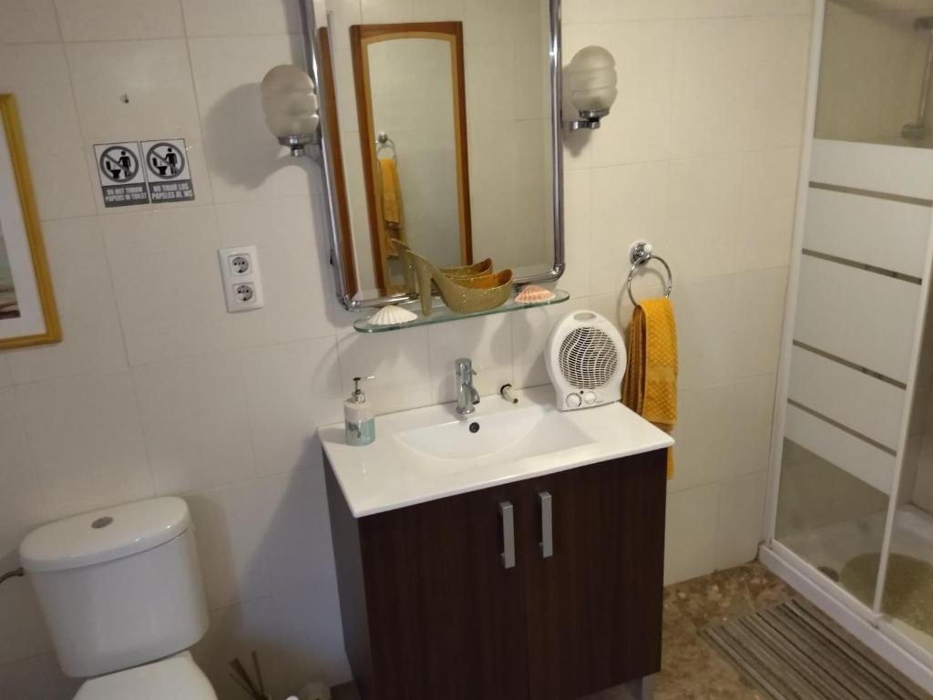 ein Badezimmer mit einem Waschbecken, einem Spiegel und einem WC in der Unterkunft Habitación hippie in Cartagena