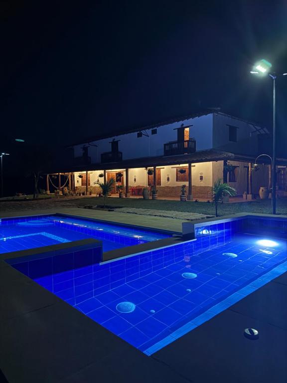 a swimming pool at night with blue lights at Hotel Palais Barichara in Barichara