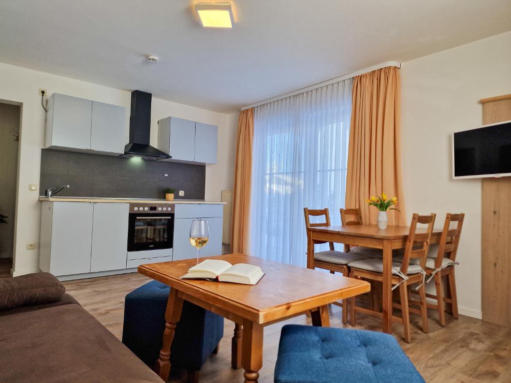 a living room with a table and a dining room at HoFer am Zeitberg Ferienwohnung Lindenbach in Bad Kohlgrub