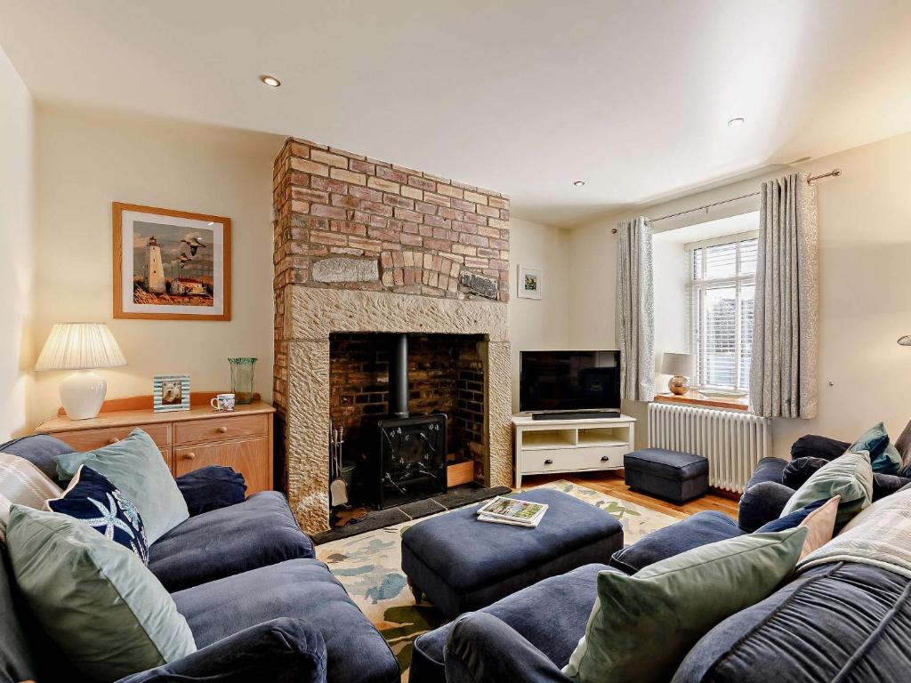 a living room with a couch and a fireplace at 3 Bed in Seahouses CN153 in Seahouses