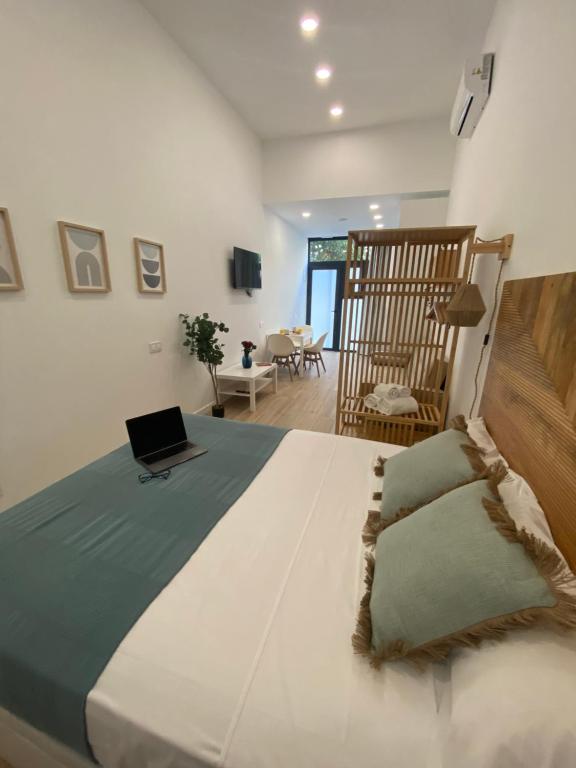 a bedroom with a bed with a laptop on it at Travel Habitat Cabanyal Lofts in Valencia