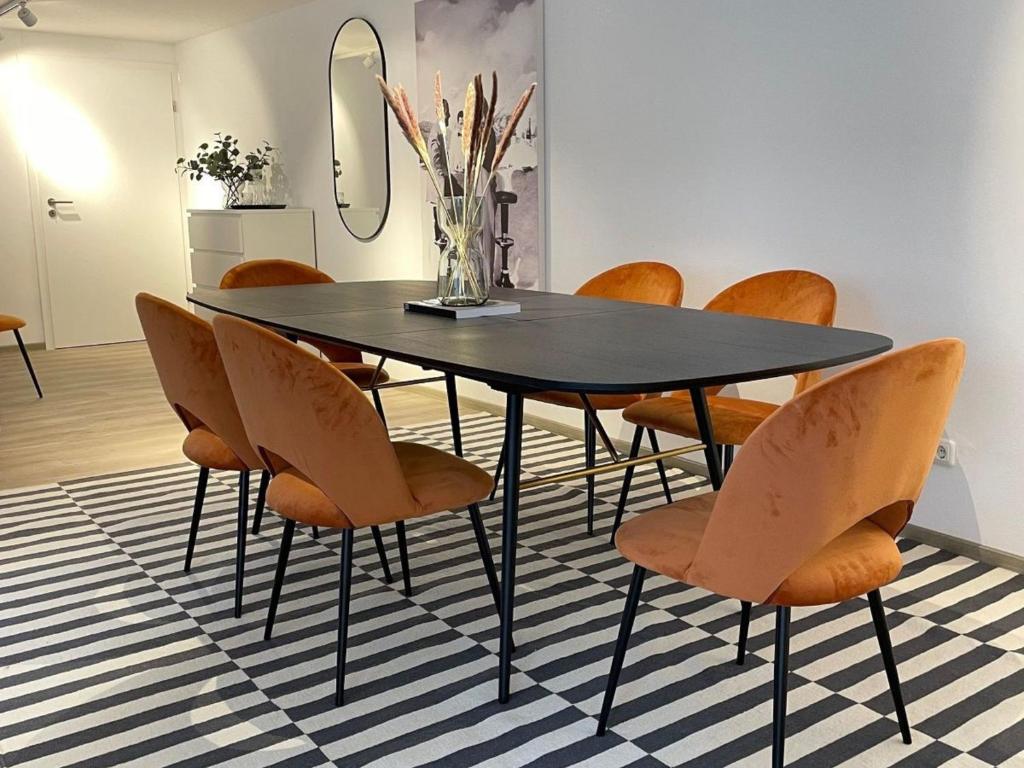 une salle à manger avec une table et des chaises noires dans l'établissement Stylische Wohnung im Herzen von Bregenz mit privatem Parkplatz, à Bregenz