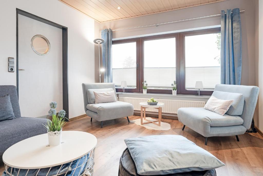ein Wohnzimmer mit einem Sofa, 2 Stühlen und einem Tisch in der Unterkunft Haus Schwanensee Seezauber in Bosau