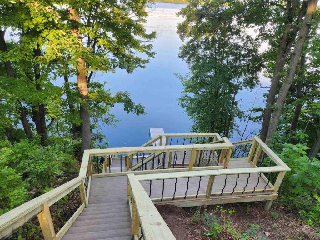 a wooden staircase leading to a lake with trees at Bliss on the Lake in Wausau