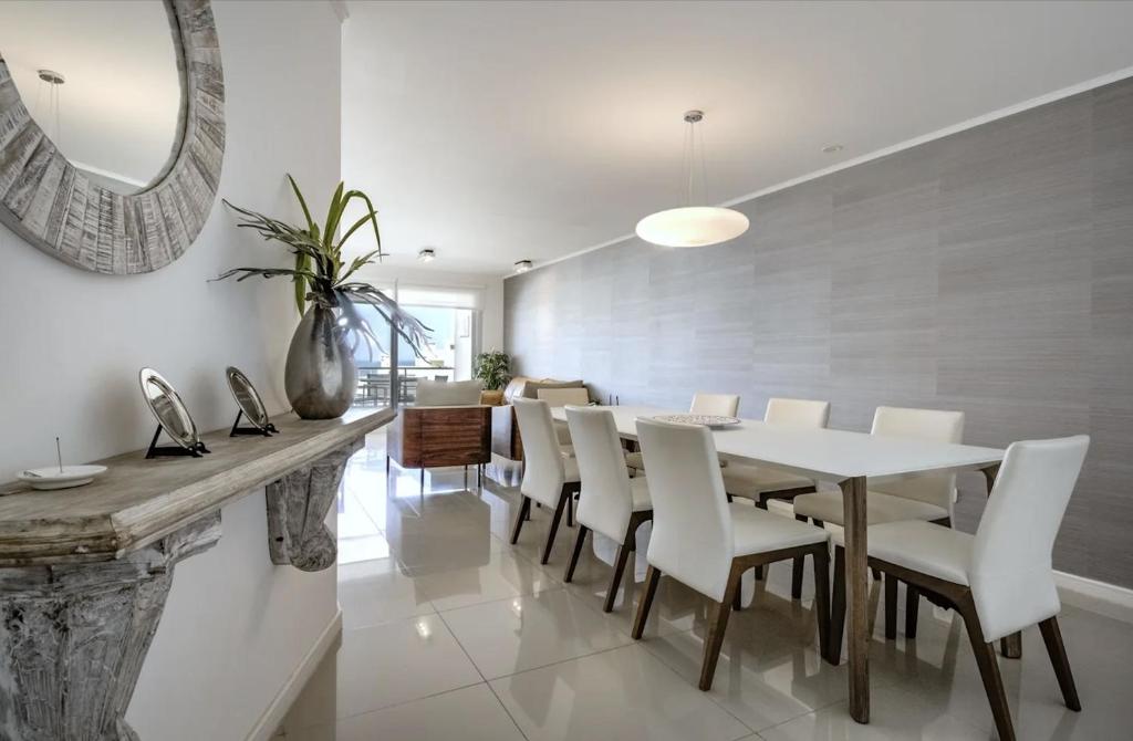 a dining room with a table and white chairs at Wind Tower, Punta del Este in Punta del Este