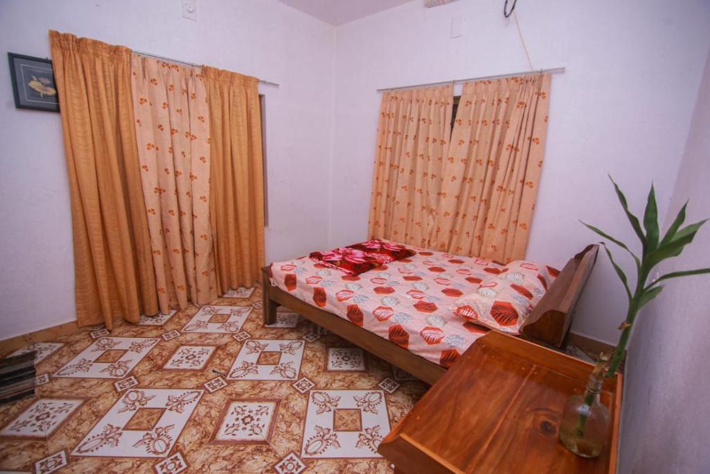 een kleine kamer met een bed en een tafel bij Maverick Holidays Inn Family Villa in Vagamon
