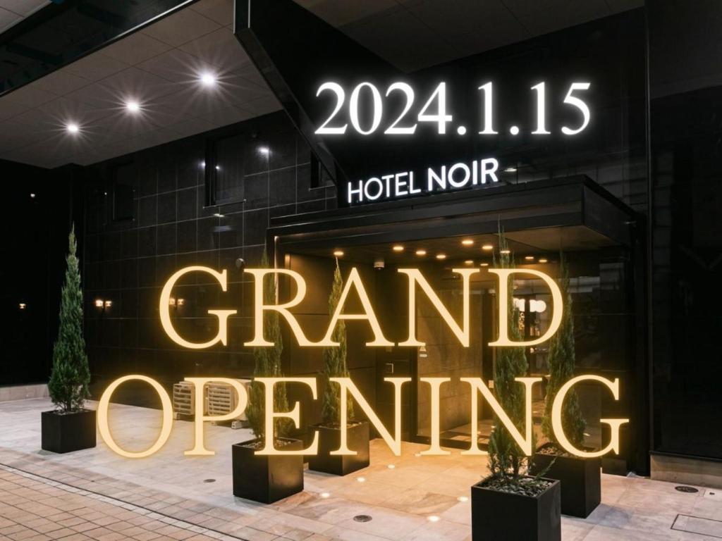 a store front with a sign that reads grand opening at HOTEL NOIR Kagoshima Chuo Station in Kagoshima