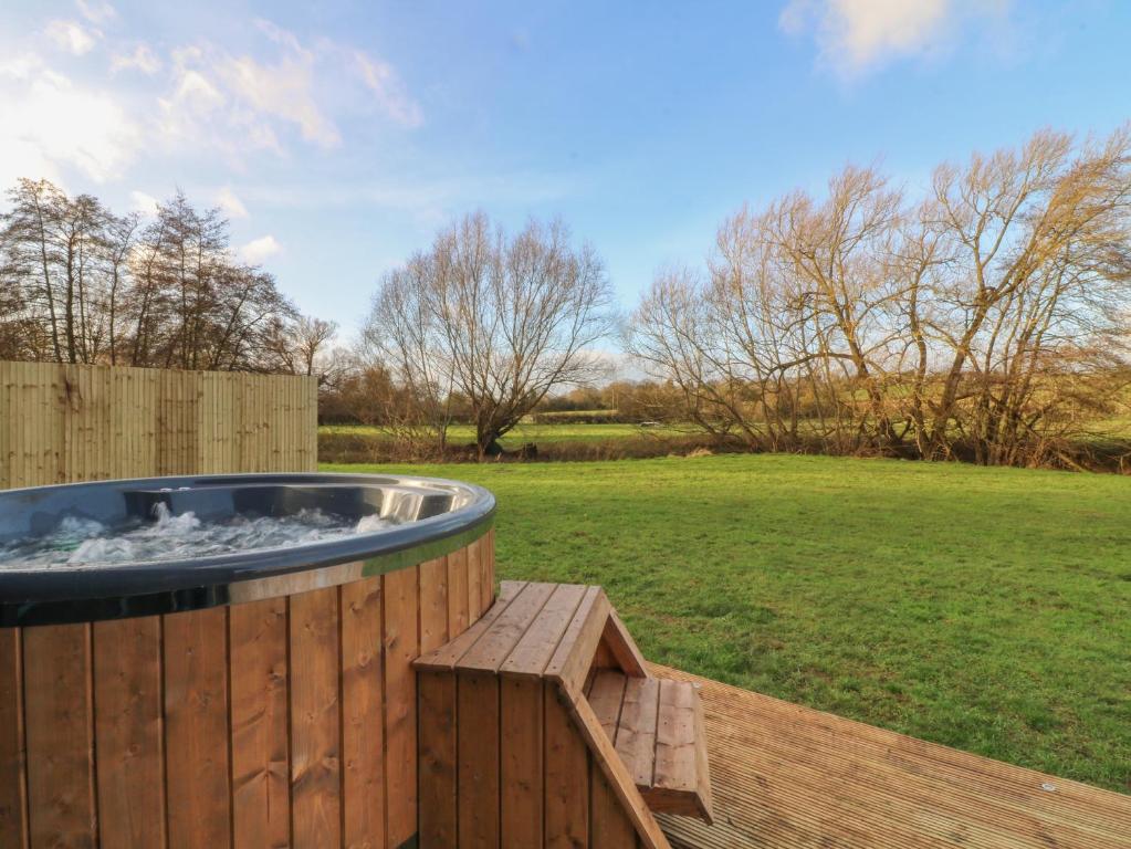 a hot tub on a wooden deck in a yard at Otter's View in Oakham