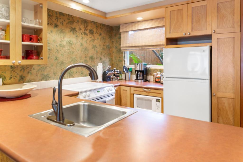 a kitchen with a sink and a white refrigerator at Lotus Suite in a Boutique Resort, 1Bedroom Sleeps 4 in Kihei