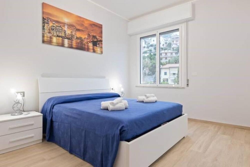 ein Schlafzimmer mit einem Bett mit zwei Handtüchern darauf in der Unterkunft TRENDY APARTMENT CLOSE to the beach in Albissola Marina