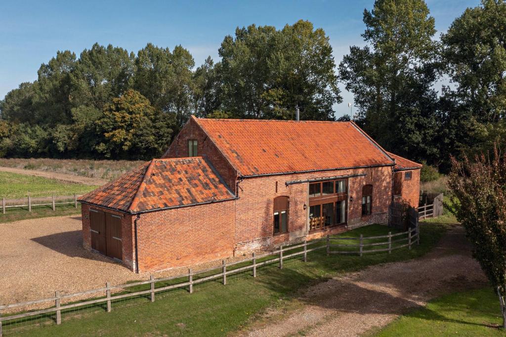 um antigo edifício de tijolos com um telhado laranja em Kings Beck Barn em Norwich