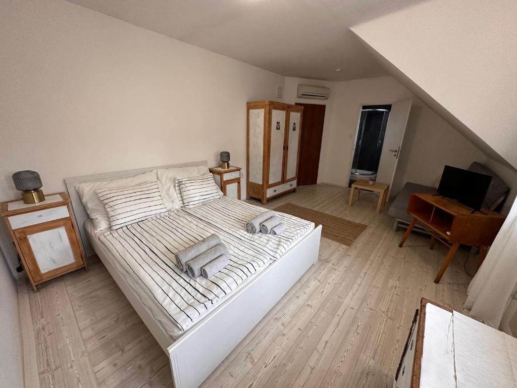 Schlafzimmer mit einem großen weißen Bett und einem Schreibtisch in der Unterkunft Penzion Na Zelnicách in Ratíškovice