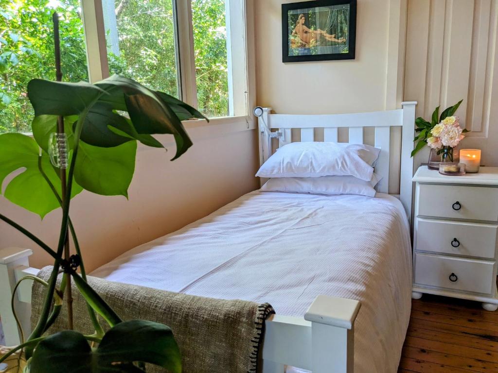 Un dormitorio con una cama blanca y una planta en Paris's Place, en Griffith