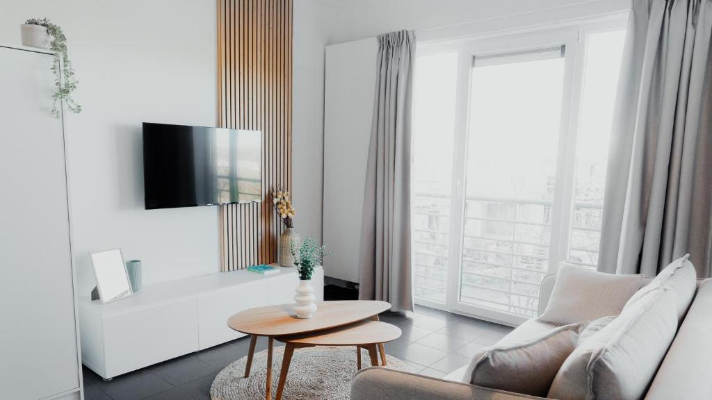 a white living room with a couch and a table at Studio Saint-Martin in Tournai