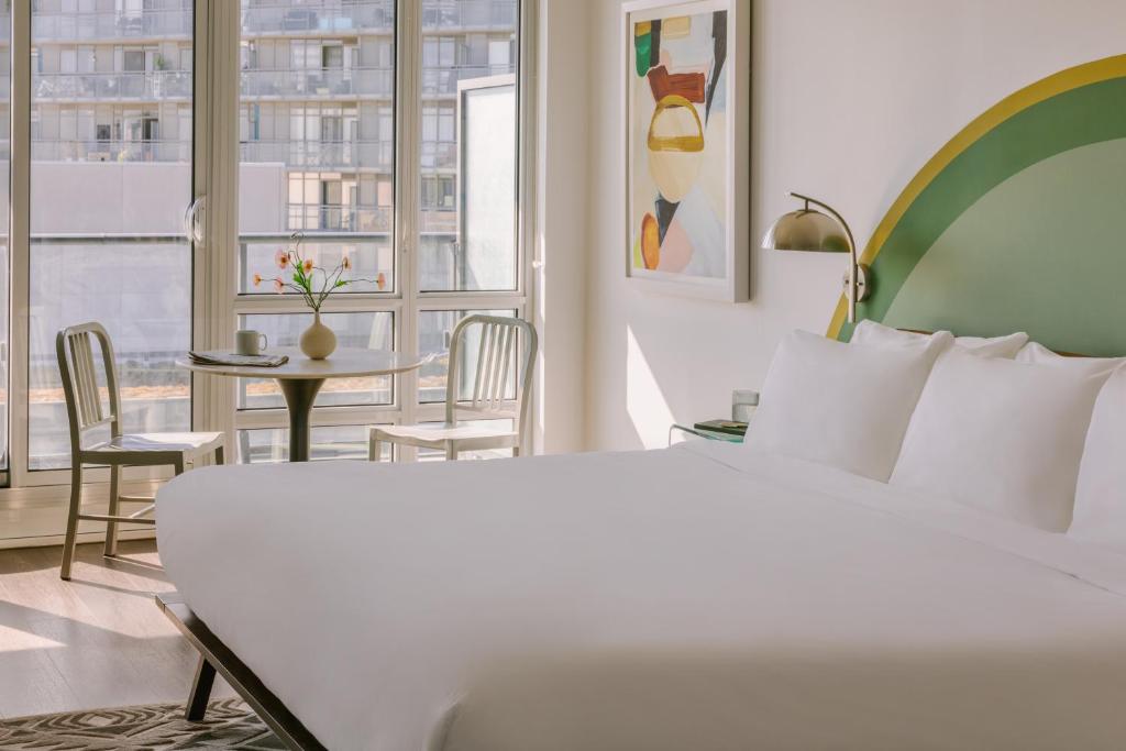 ein Hotelzimmer mit einem Bett und einem Tisch mit Stühlen in der Unterkunft Sonder at The Liberty in Toronto
