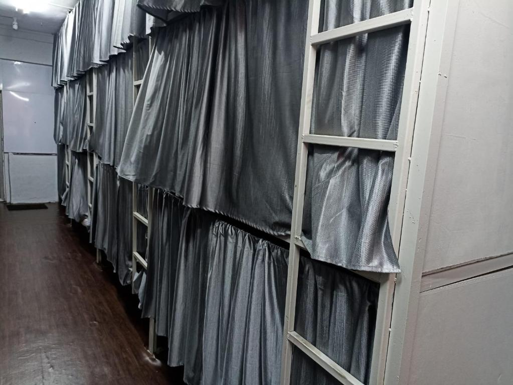 a row of windows covered in plastic in a room at Saffron Dormitory Goregaon East in Mumbai