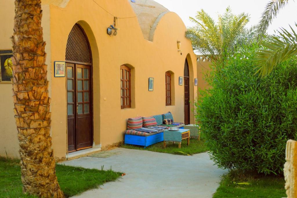 eine Terrasse eines Hauses mit einer blauen Couch in der Unterkunft Sekhmet Retreat Centre in Luxor