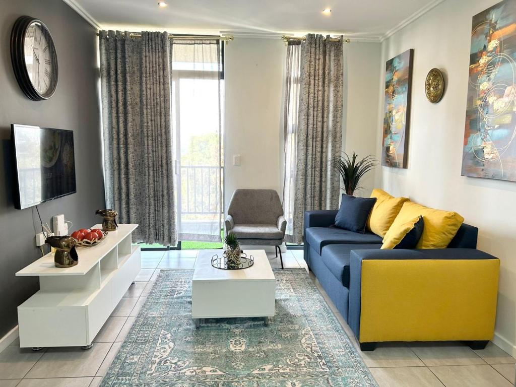 een woonkamer met een blauwe bank en een gele stoel bij Lilly's Gold in Johannesburg