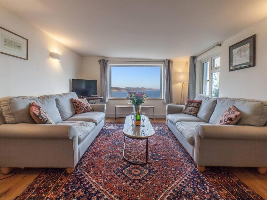 a living room with two couches and a table at Holme Cleve - enjoy the best view of Lyme Regis in Lyme Regis