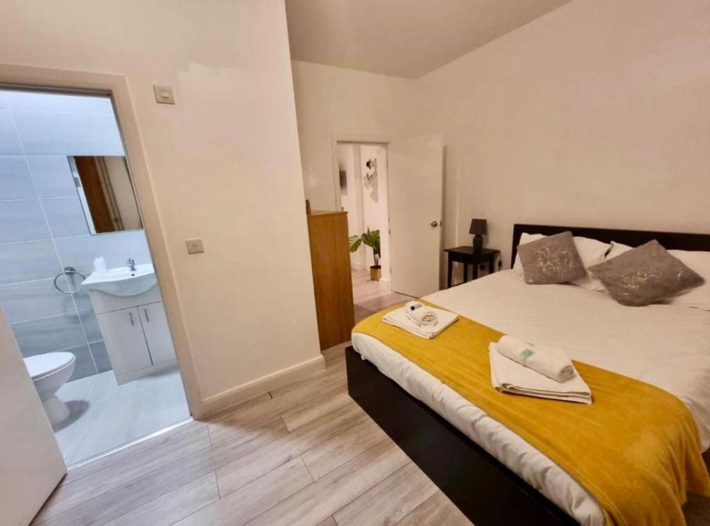 a bedroom with a bed and a bathroom with a sink at Three bed Ensuites in Edgware in Edgware