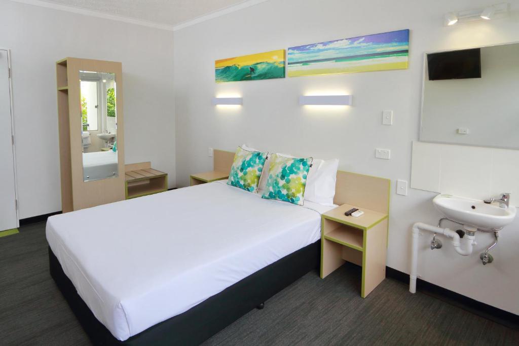 Habitación de hotel con cama y lavabo en Palm Beach Hotel en Gold Coast