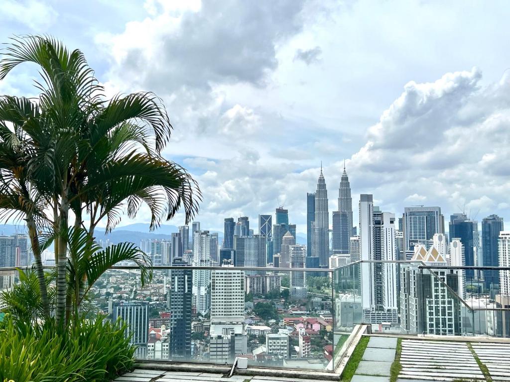 eine Palme auf einer Skyline der Stadt in der Unterkunft Regalia service apartment by premire suites in Kuala Lumpur