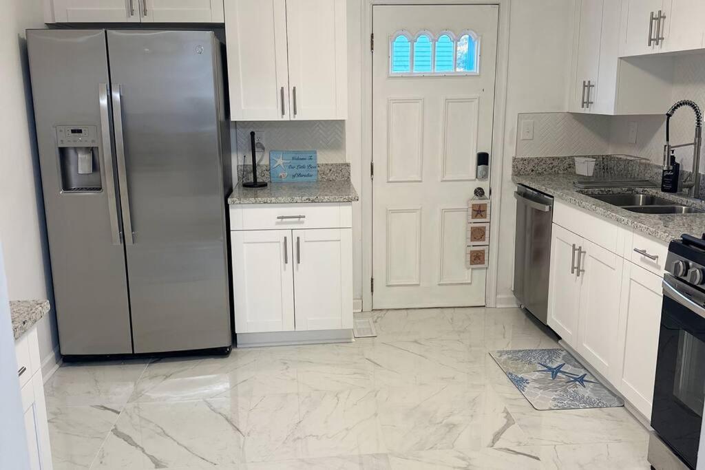 a kitchen with white cabinets and a stainless steel refrigerator at Ocean Haus in Portsmouth