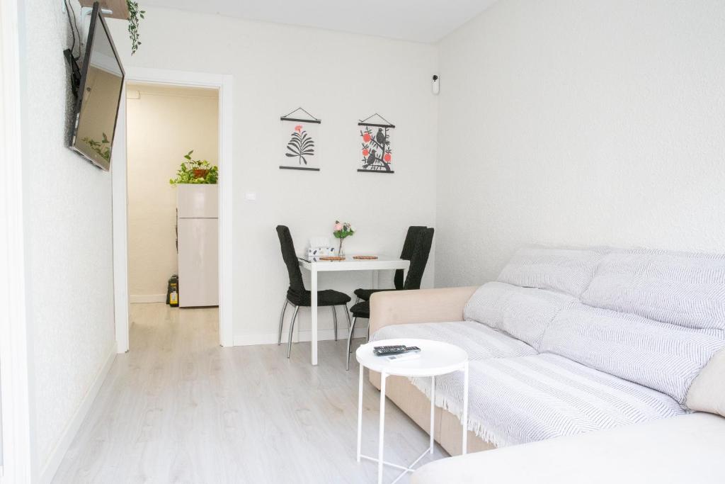 uma sala de estar com um sofá branco e uma mesa em Precioso apartamento en Premià de Dalt em Premia de Dalt