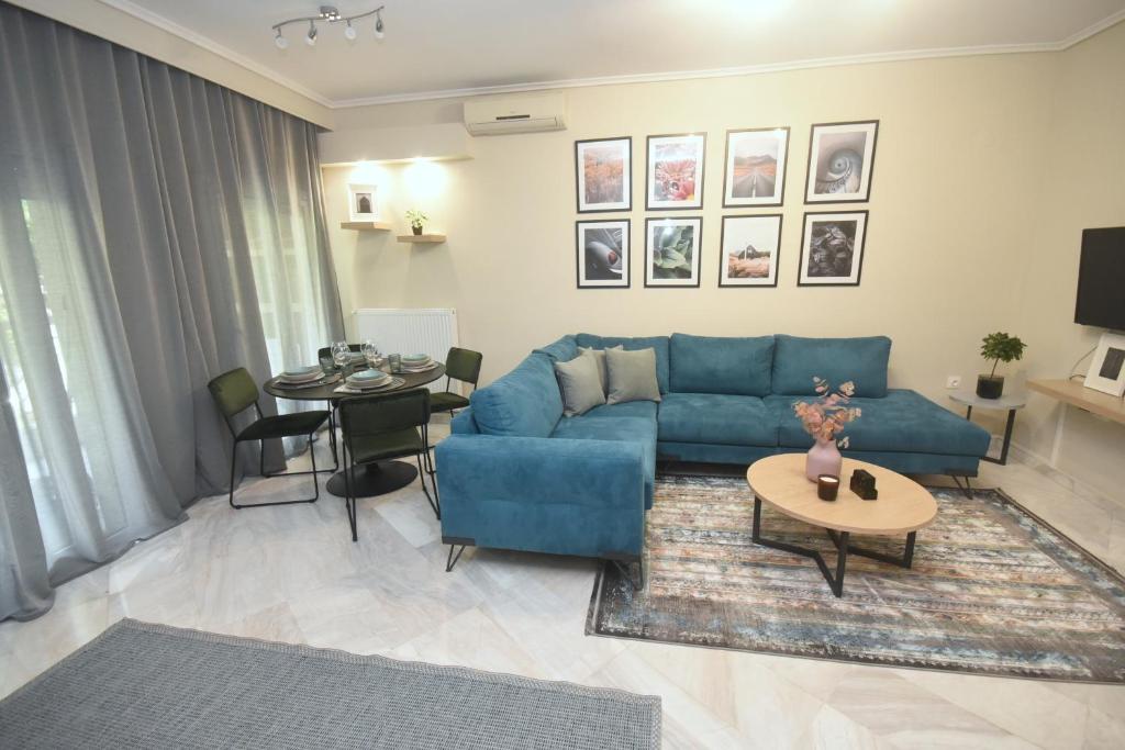 uma sala de estar com um sofá azul e uma mesa em MATS APARTMENT em Tessalônica