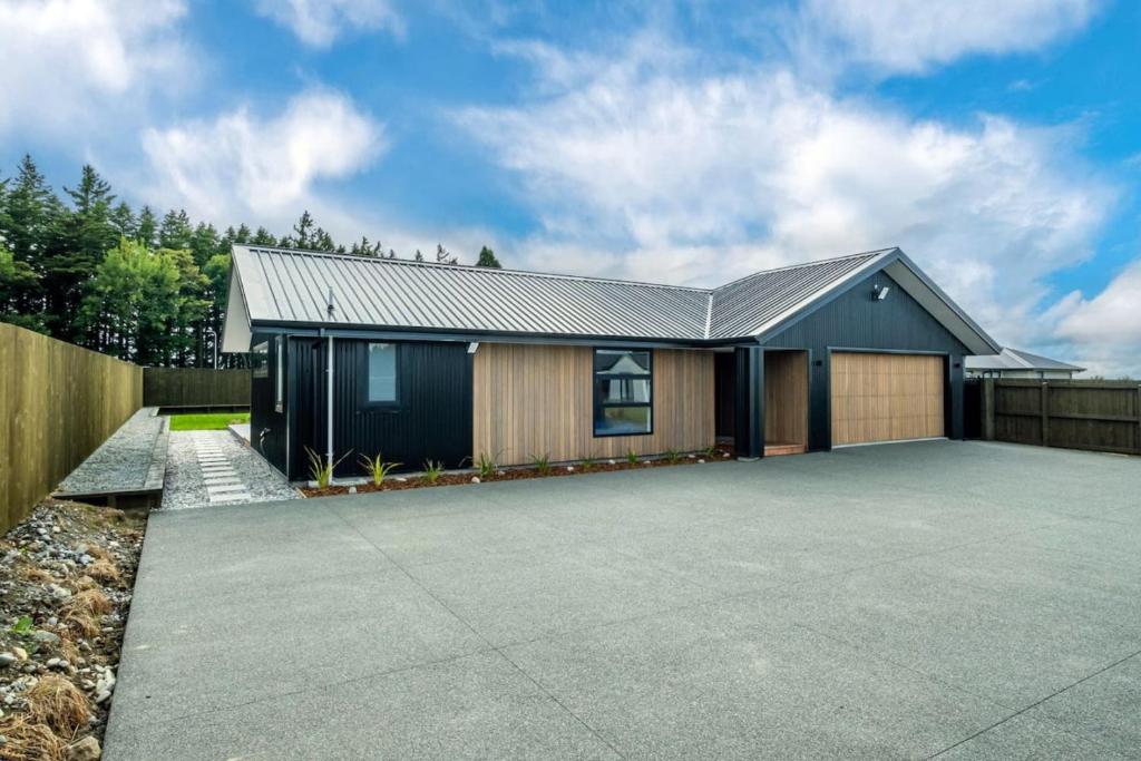 a house with a driveway and a fence at Elegant, Executive Retreat in Methven