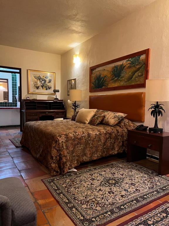 a bedroom with a bed and a piano at Casa Tlaquepaque in Guadalajara