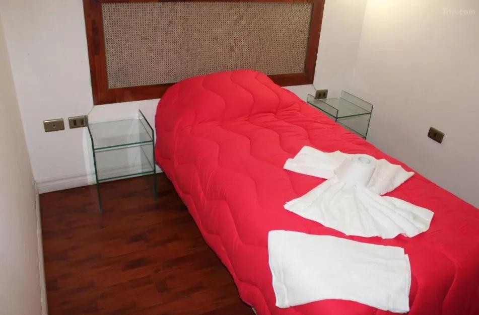 un sofá rojo en una habitación con 2 mesas de cristal en Bitton Hotel Boutique, en Santiago