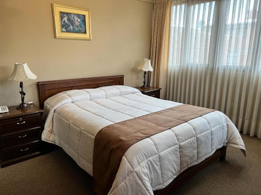 a bedroom with a large bed and a window at Hotel Santa Teresa in Potosí