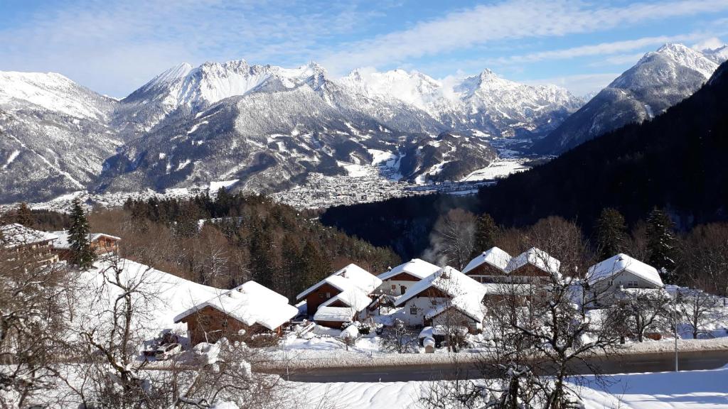 a village covered in snow with mountains in the background at Landhaus Berthold in Bürserberg