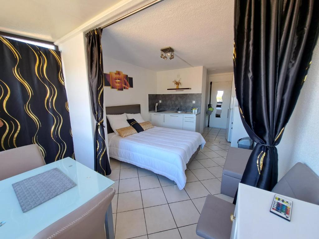 um quarto de hotel com uma cama e uma cozinha em Naturistecapdagde APHRODITE em Cap d'Agde