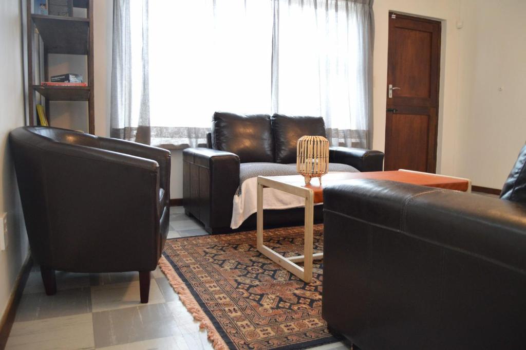 a living room with a couch and a table and chairs at Cottage on Diamond Street in Swakopmund