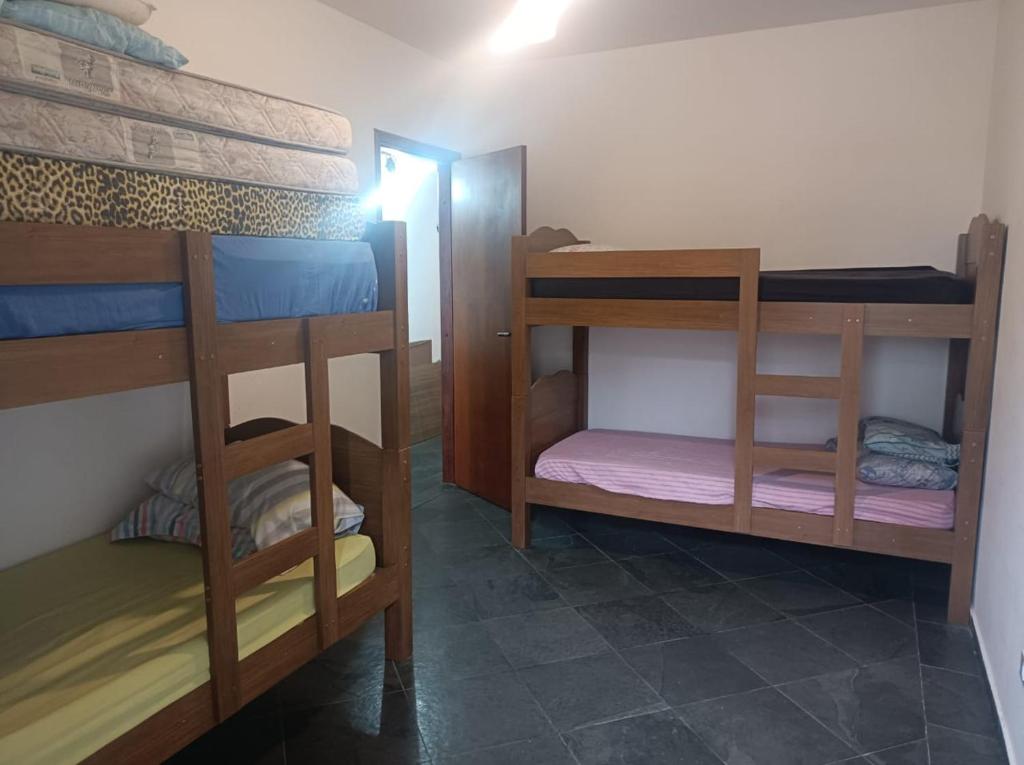 een kamer met 3 stapelbedden in een kamer bij Enseada Guarujá Ap214 in Guarujá